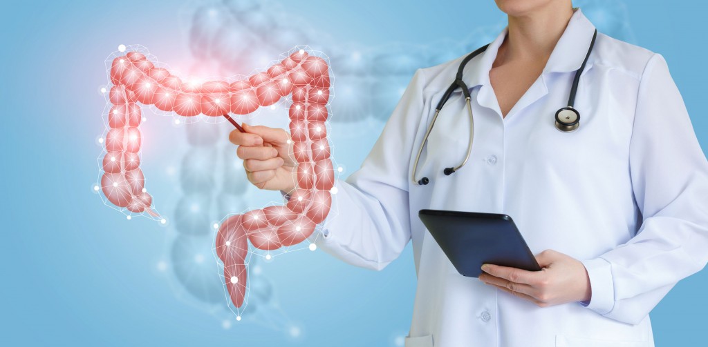 Doctor shows colon on virtual screen over blue background.