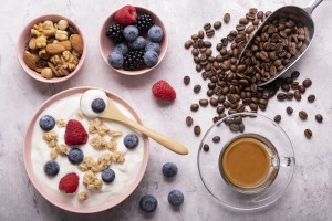Concept of healthy nutrition. Food for breakfast, top view, a bowl with low-fat yogurt, crunchy oatmeal, dried fruit, fresh fruit and espresso.