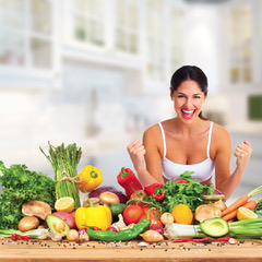 Happy laughing young woman and vegetables on the table